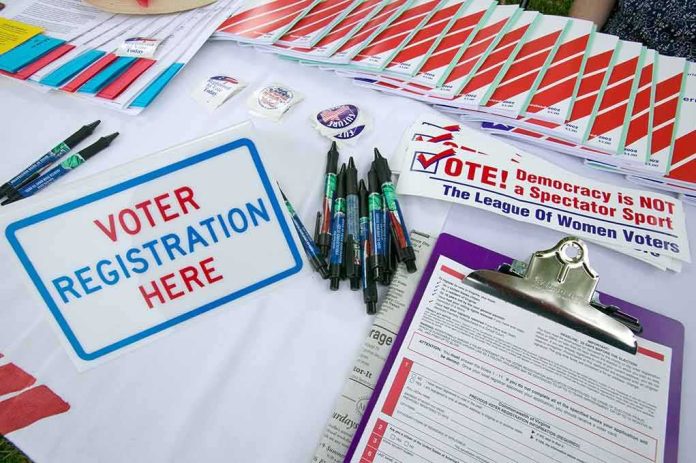 Voter registration table with forms, pens, and informational materials