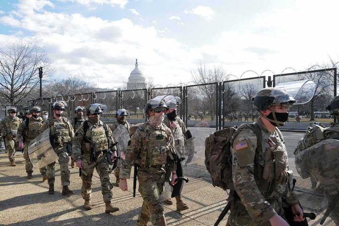 Soldiers in riot gear patrol near a fenced government building
