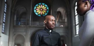Priest talking with a visitor inside a church