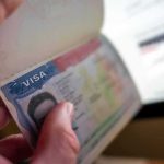 Hand holding a passport with a visa page