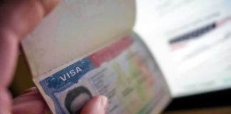 Hand holding a passport with a visa page