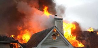 ‘Armed and Dangerous’ Fugitive Arrested in Father’s Murder and House Fire House engulfed in flames with heavy smoke from the roof