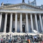 Socialist Mayor Faces RECALL Over Criminal Allegations Reporters and photographers gathered outside a neoclassical courthouse
