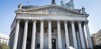 Reporters and photographers gathered outside a neoclassical courthouse