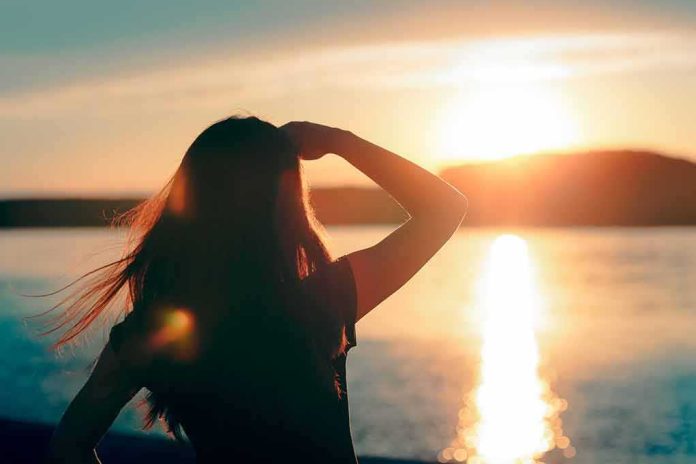 Silhouette of a person looking at a sunset over water