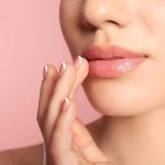 Close-up of woman's lips with hand touching