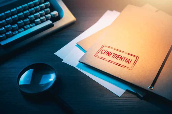 shutterstock_1188557530 Confidential file folder on desk with magnifying glass and typewriter