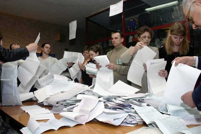 People counting ballots at a table