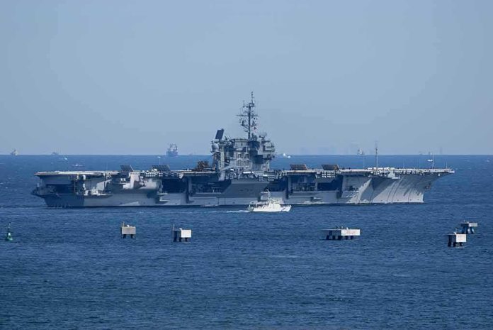 shutterstock_1314966416 Aircraft carrier at sea with small boat alongside