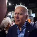 Joe Biden greets people at an indoor event