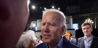 Joe Biden greets people at an indoor event