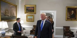 Donald Trump walks through an office with Sean Lawler nearby and Mariano Rajoy following behind