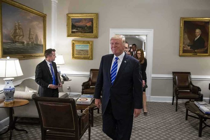 Donald Trump walks through an office with Sean Lawler nearby and Mariano Rajoy following behind