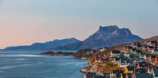 Colorful coastal town with mountains and sea at sunset