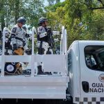 National guard officers standing on a patrol truck