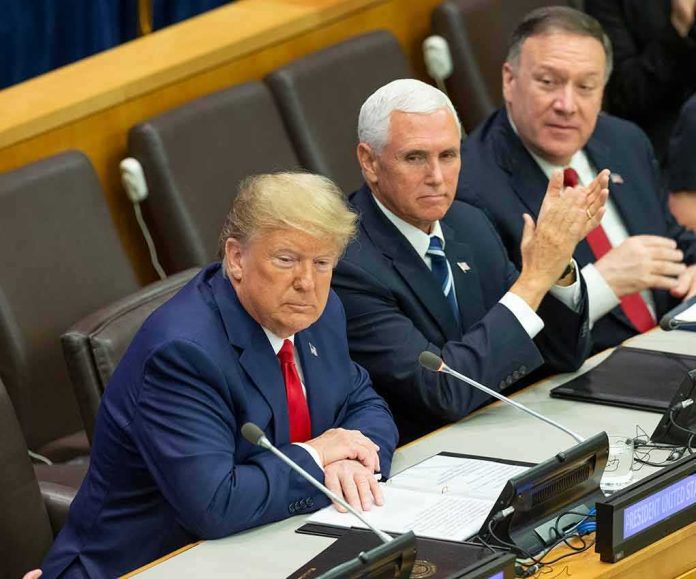 three men in suits seated at a conference table