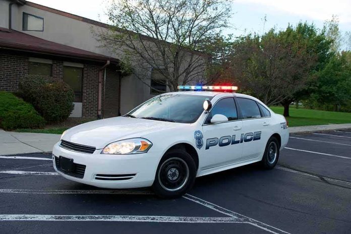 Police car with flashing lights parked outside a building