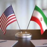 Trump Approval Crucial: US-Iran Ceasefire Hinges! United States and Iran desk flags on a stand
