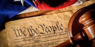 U.S. Constitution with gavel and flag
