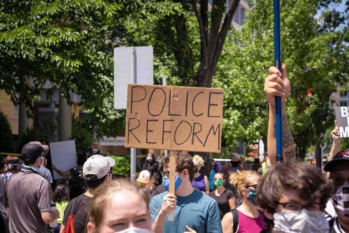 Protesters holding a cardboard sign reading Police Reform