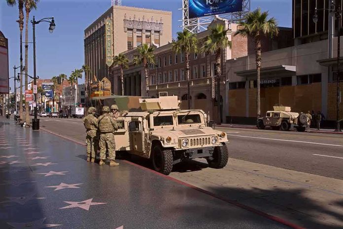 Soldiers beside a military Humvee on a palm-lined city street
