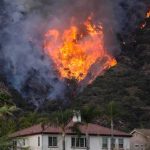 Powerful Winds Turn Reno Fire Into a Race Against Time Wildfire burning on a hillside near homes