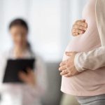 Country Expands Who Gets Bereavement Leave Pregnant woman holding belly during medical visit