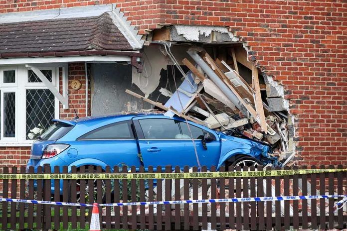 shutterstock_2101437247 Blue car crashed into brick house wall