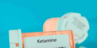 Prescription pill bottle labeled ketamine on a blue background
