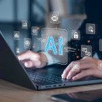 Hands typing on laptop with AI and tech icons overlay