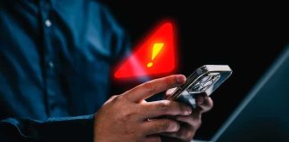 hands holding smartphone with warning alert icon