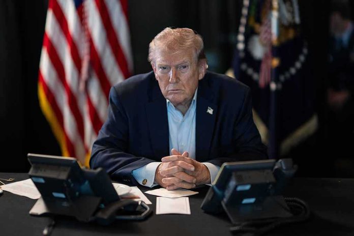 shutterstock_2747572821 Donald Trump seated at a table between two desk phones
