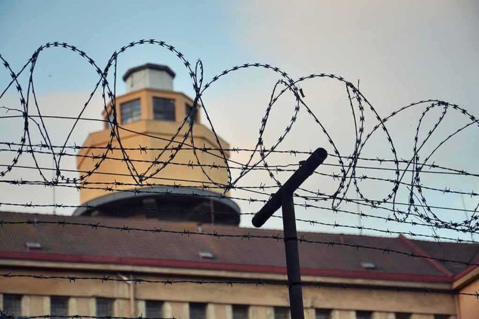 Barbed wire fence in front of a prison watchtower