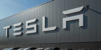 Tesla cars parked outside a large Tesla building