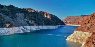 Reservoir between rugged desert cliffs with stark white shoreline