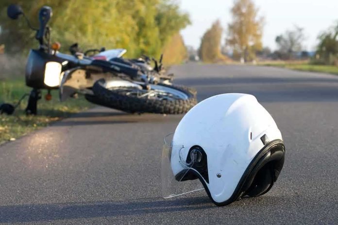 White motorcycle helmet on road with fallen bike in background