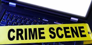 Laptop keyboard with yellow crime scene tape across it