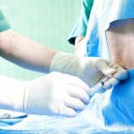 Irreversible Detransitioning Decisions Under Fire Healthcare professional administering an injection to a patient in a surgical setting