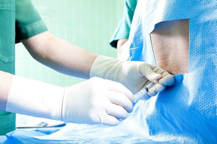 Healthcare professional administering an injection to a patient in a surgical setting