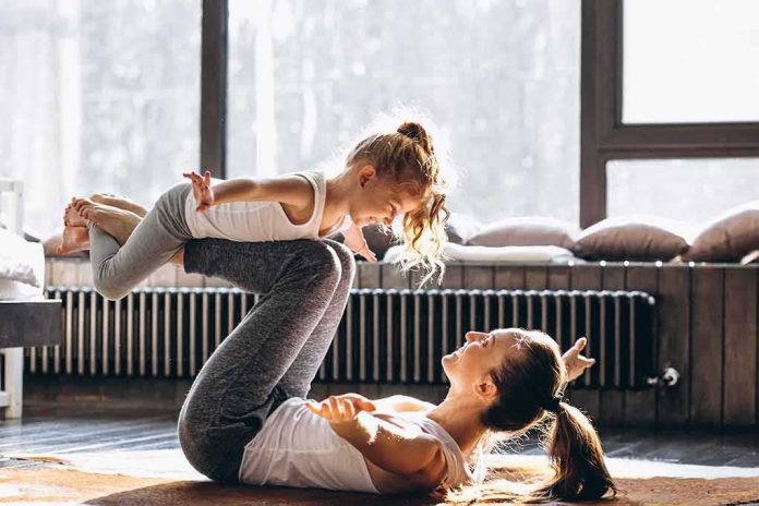 shutterstock_1033938349 Mother and daughter doing airplane pose together at home