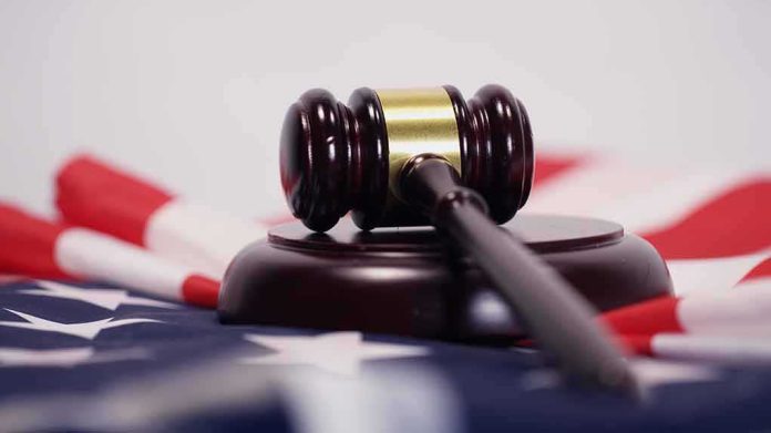 shutterstock_1050534611 Judge’s gavel on a base over an American flag