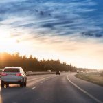 Cars driving on a highway at sunset