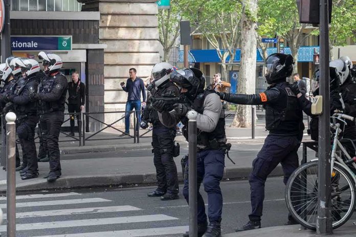 Riot police in helmets line a city street during an operation