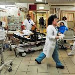 Hospital emergency room with staff moving patients on stretchers
