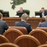 Business meeting attendees facing a panel in a conference room