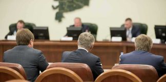 Business meeting attendees facing a panel in a conference room