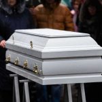 White casket at an outdoor funeral