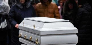 White casket at an outdoor funeral