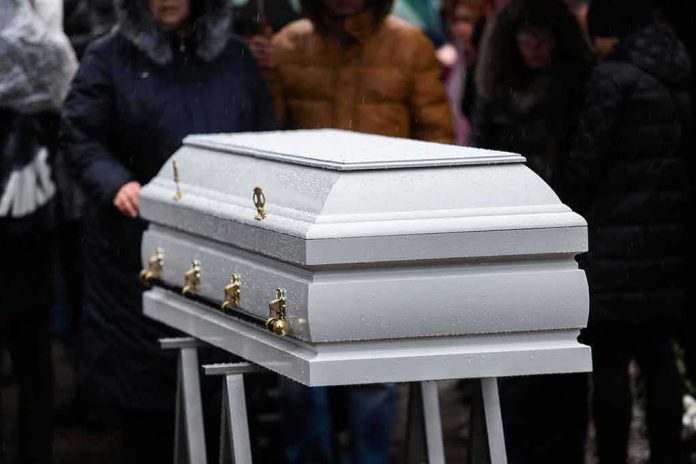 White casket at an outdoor funeral