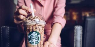 Iced blended coffee drink with chocolate drizzle held by a person